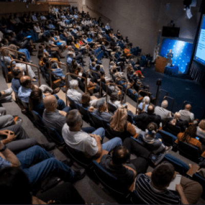 Many individuals gathered in a lecture hall, engaged in a presentation or discussion.
